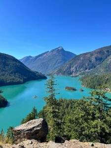 Turquoise Diablo Lake surrounded by forested mountains under a clear sky in Washington